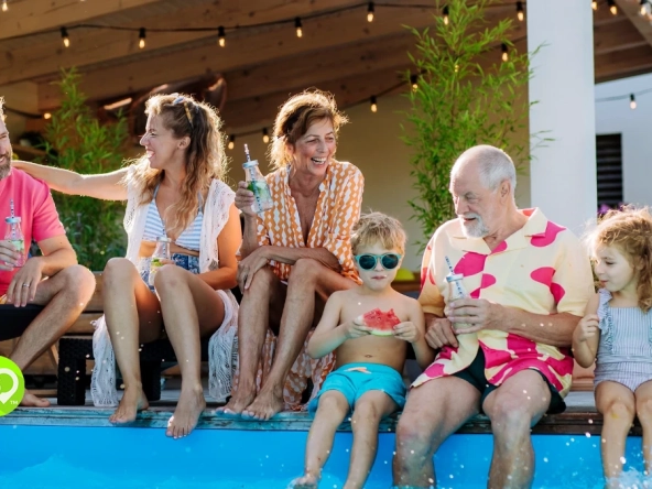 International Timeshare Appreciation Day: a multi-generational family sitting at the edge of a pool