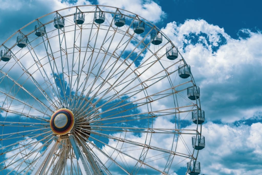 Ferris wheel against a cloudy blue sky in Ocean City, Maryland, one of the best boardwalks on the East Coast