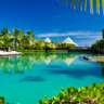 palm-lined lagoon with thatched huts