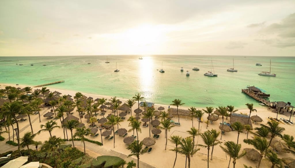Palapas on Palm Beach at sunset near Barceló Aruba