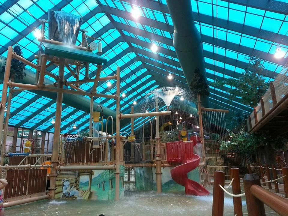 The indoor water park play structure and red slide under a glass roof at Westgate Smoky Mountain Resort.
