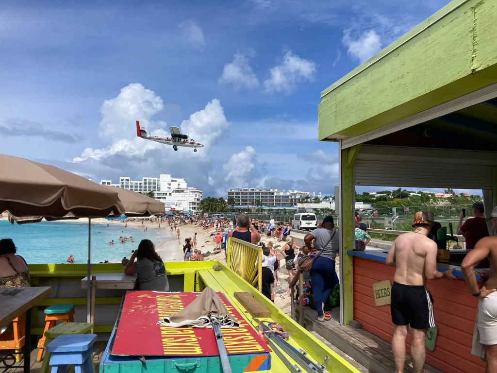 Plane landing over a crowded Maho Beach in Sint Maarten