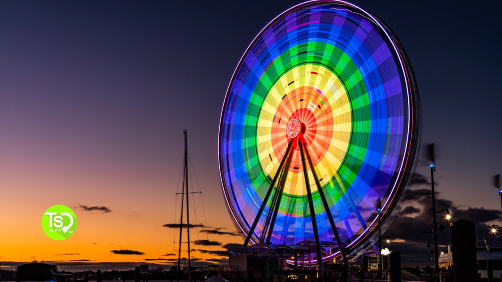 The Capital Wheel at night glowing with rainbow colors over the Potomac River near Club Wyndham National Harbor.