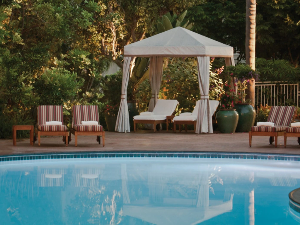Relaxing swimming pool reflecting a private, draped cabana and lounge chairs at the Four Seasons Residence Club Aviara.