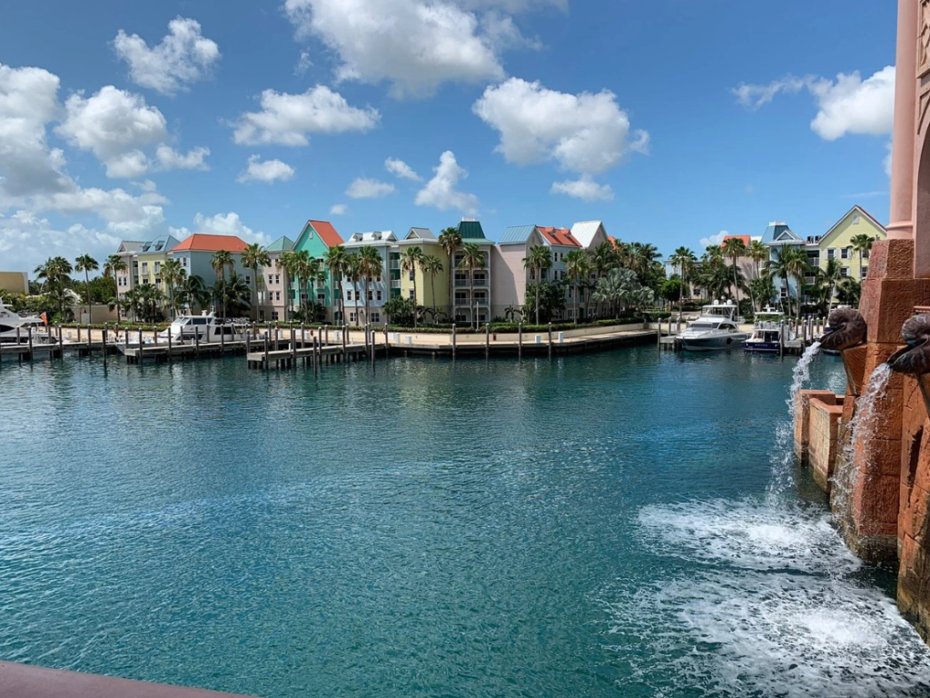 Colorful pastel villas along a harbor waterfront with docked yachts, perfect for warm weekend getaways.