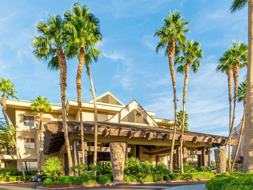 Tall palm trees frame the tropical entrance of Tahiti Village Resort, perfect for warm weekend getaways.