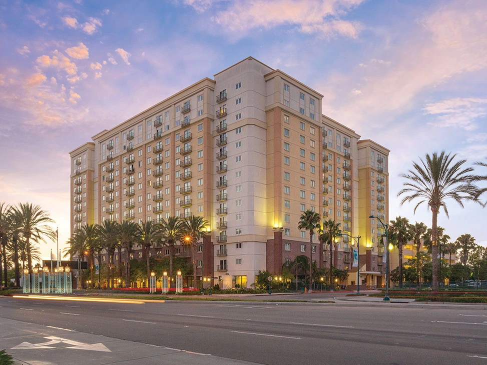 Exterior of Anaheim Resort at dusk; consider this resort when researching the Pros and Cons of Wyndham Timeshare.