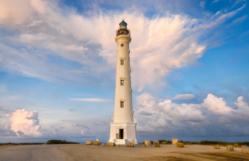 Tall white lighthouse on Aruba's sandy coast—a scenic landmark for travelers researching what to do in Aruba.