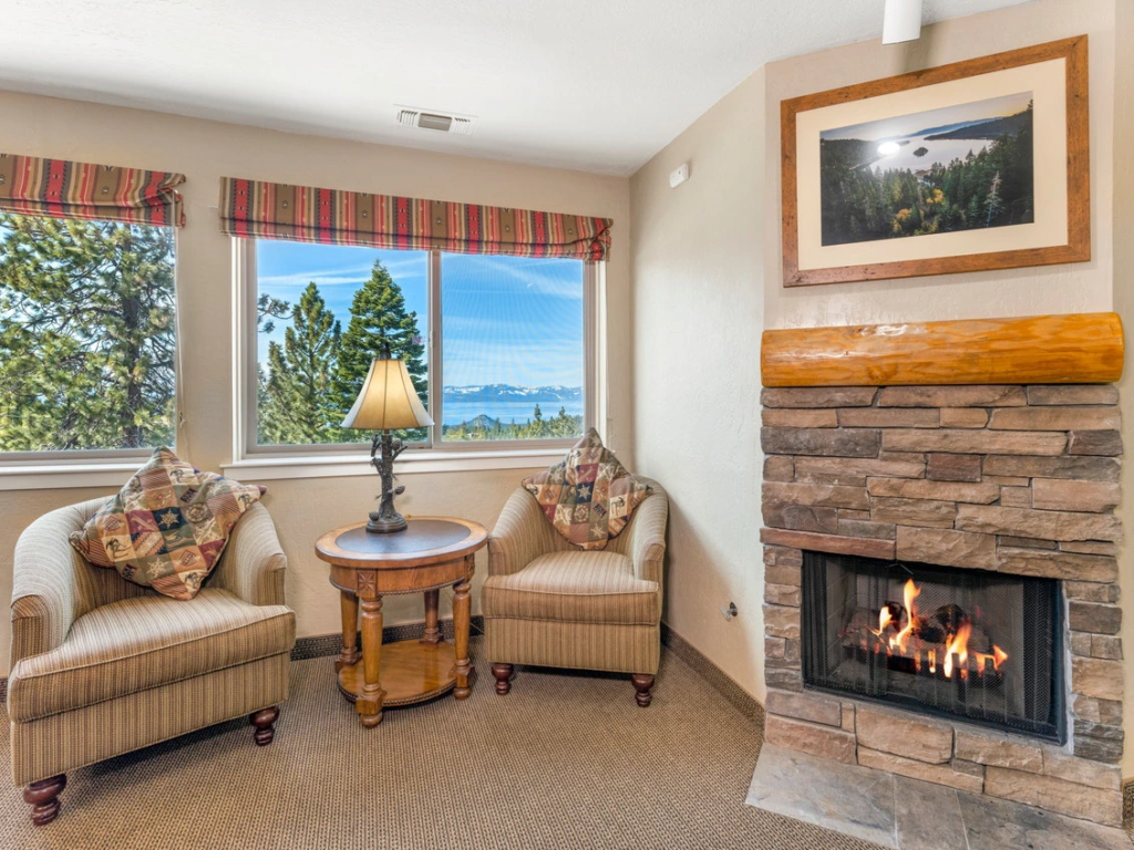The Ridge Tahoe living area with a fireplace and lake view. Weigh the Pros and cons of Holiday Inn Vacation Club here.