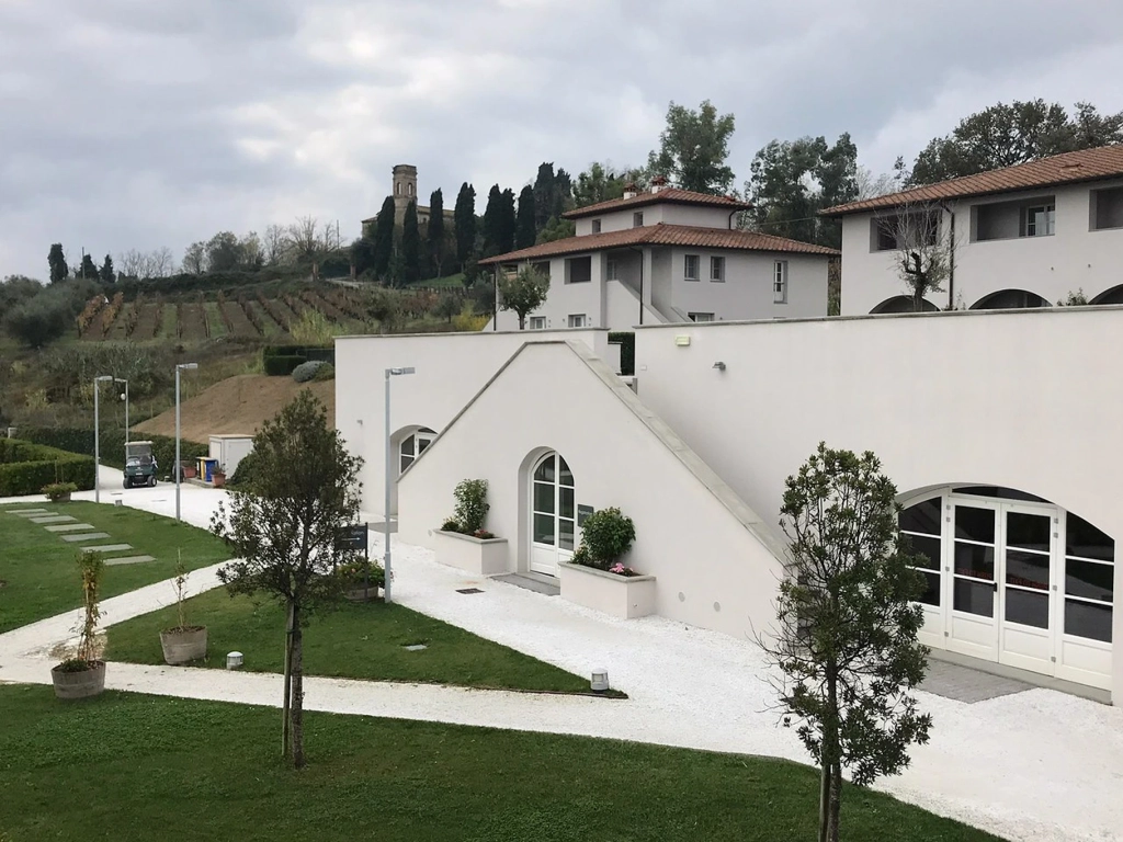 White stucco villa architecture and rolling vineyards at Borgo alle Vigne. Is Hilton Grand Vacations Worth It?