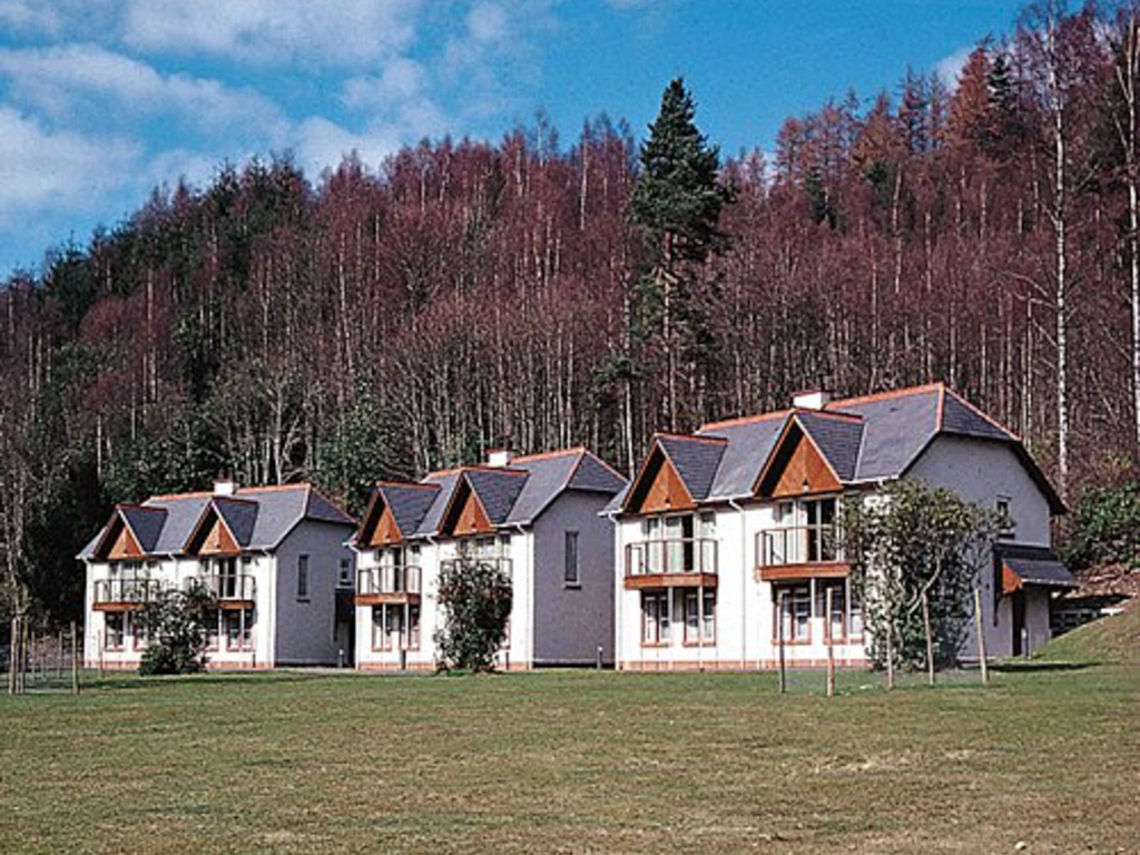Charming white vacation villas at Dunkeld set against a dense forest. Is Hilton Grand Vacations Worth It?