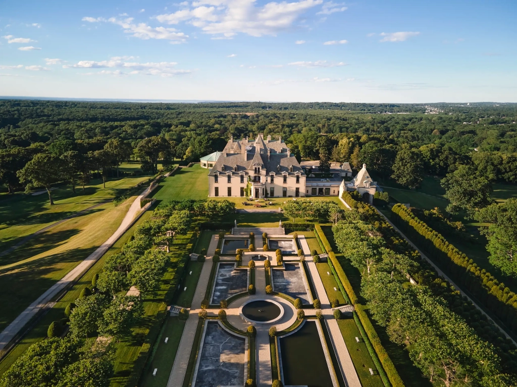 Aerial view of a French chateau perfect for Romantic Getaways, with parterre gardens, reflecting pools, and surrounding woodlands.