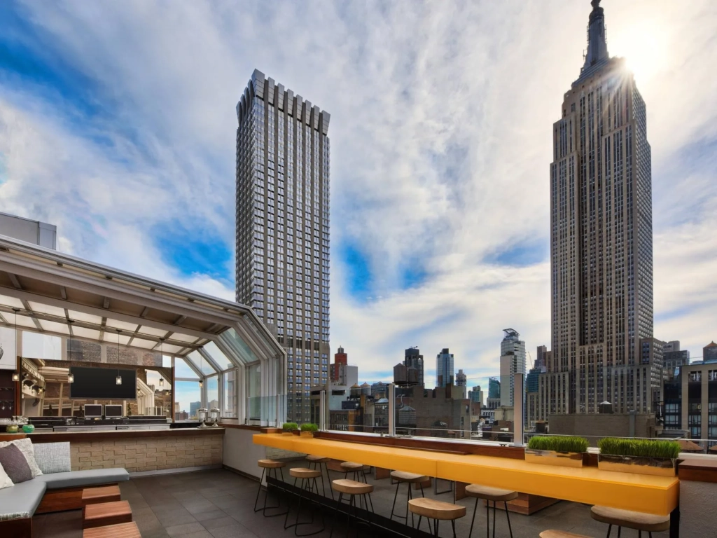 Rooftop terrace with yellow bench seating overlooking the Empire State Building at Marriott Vacation Club, New York City.