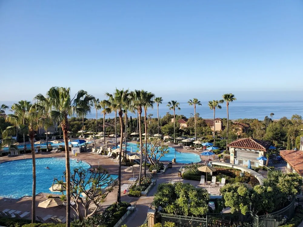 Aerial view of the pools at Marriott's Newport Coast Villas, a Marriott timeshare points chart resort, with the ocean beyond.