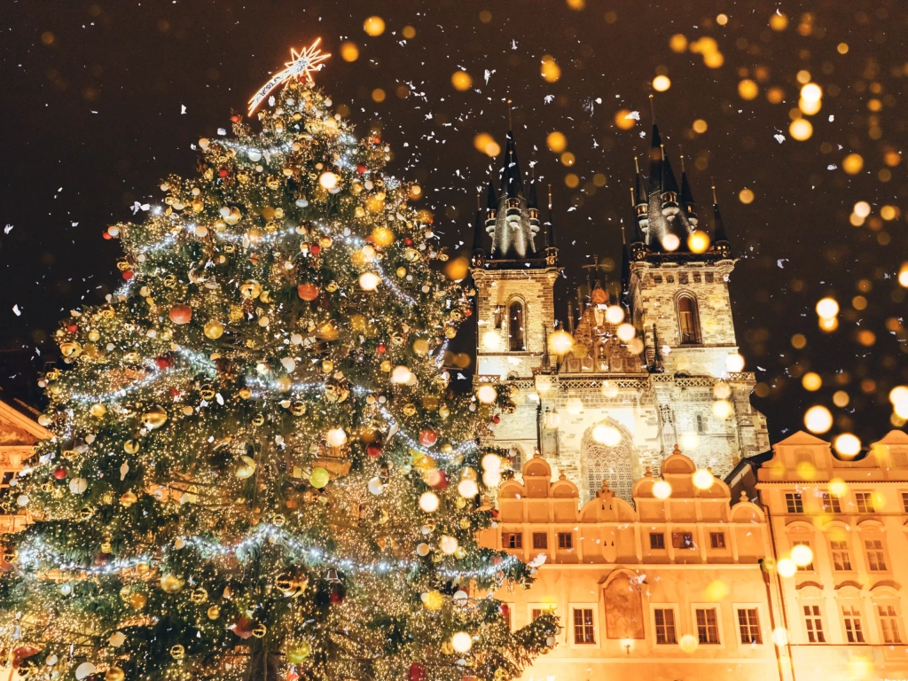 Snow-dusted Prague Old Town Square Christmas tree glowing with golden lights — perfect for Romantic Getaways near the Týn Church.