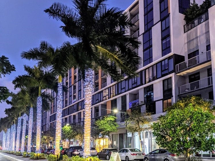Light-wrapped palm trees along a street at CityPlace Doral, one of the things to do in Miami at night