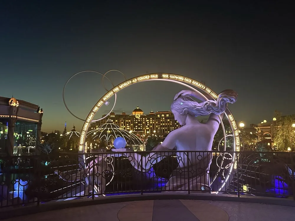 Illuminated mermaid statue beneath a glowing arch at the theme park where epic universe tickets grant access to twilight magic.