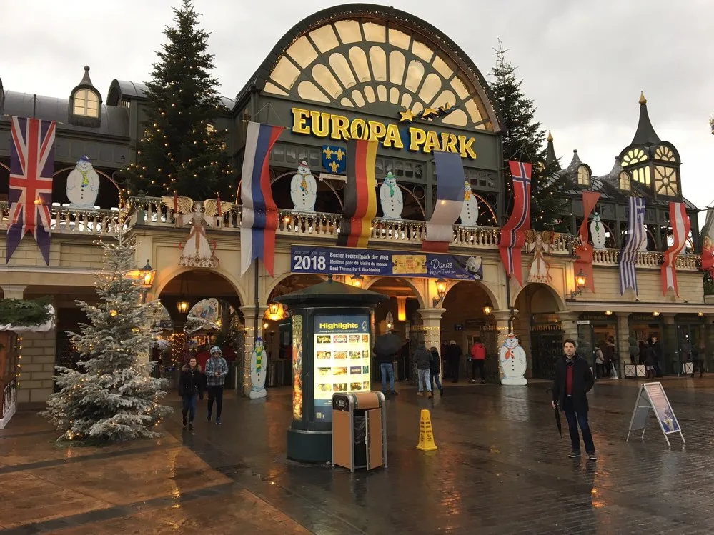 The main entrance to Europa-Park, one of the best theme parks in the world, decorated with Christmas trees, snowmen, and flags on a winter day.