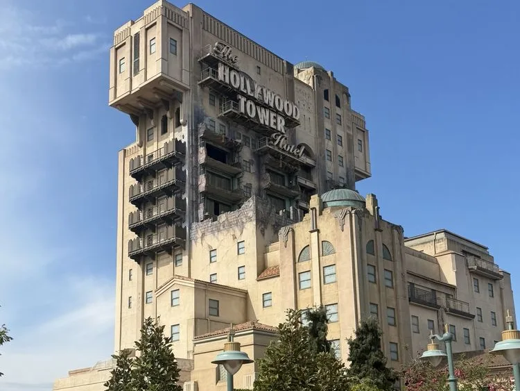 The weathered Art Deco facade and scorched exterior of the Hollywood Tower Hotel, a signature attraction at one of the best theme parks in the world.