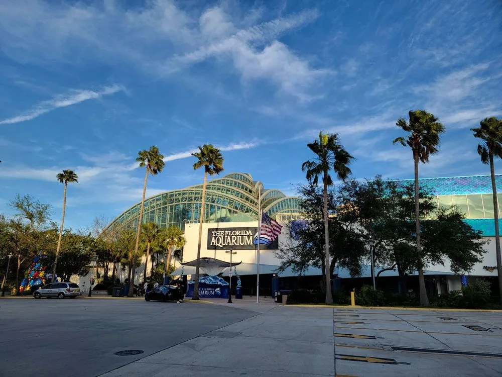 The Florida Aquarium's glass dome and palm trees in Tampa, a popular stop on day trips from Orlando
