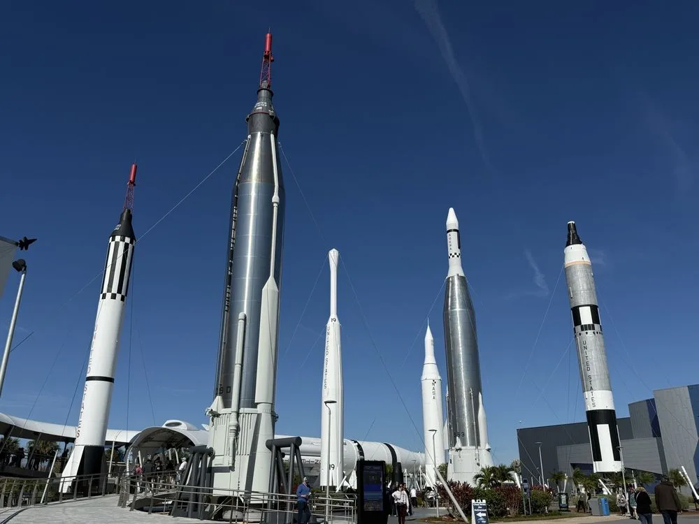 Rocket Garden at Kennedy Space Center featuring multiple historic NASA rockets displayed outdoors under a clear blue sky.