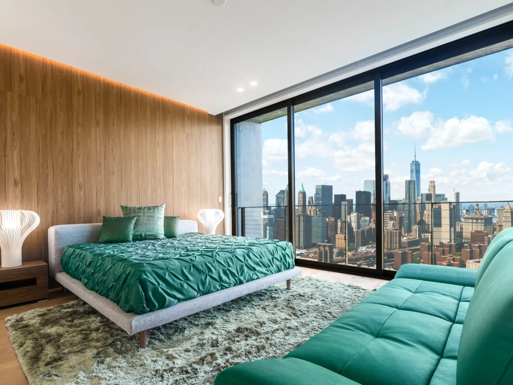 Bedroom with floor-to-ceiling windows overlooking the Manhattan skyline