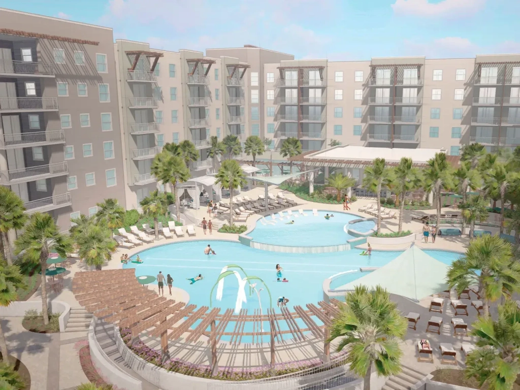 Aerial view of Holiday Inn Club Vacations' New Myrtle Beach Resort's freeform pool with palm trees, lounge chairs, and multi-story buildings.