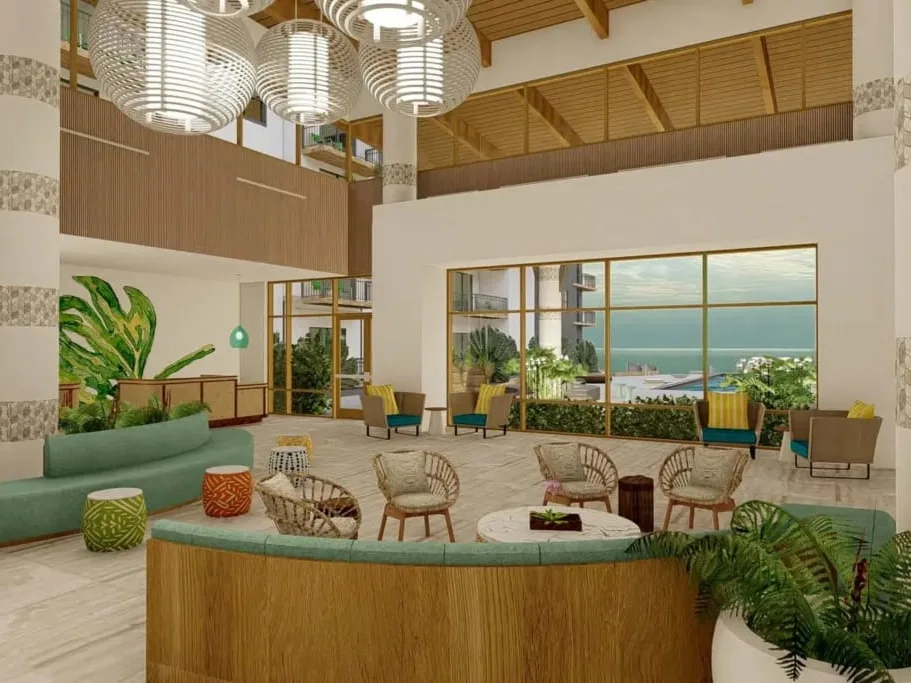 Holiday Inn Club Vacations' New Myrtle Beach Resort lobby with rattan seating, tropical plants, and ocean-view windows.
