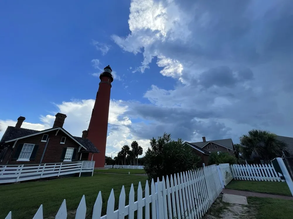Red brick lighthouse and keeper cottages at Ponce Inlet, a classic stop on day trips from Orlando.