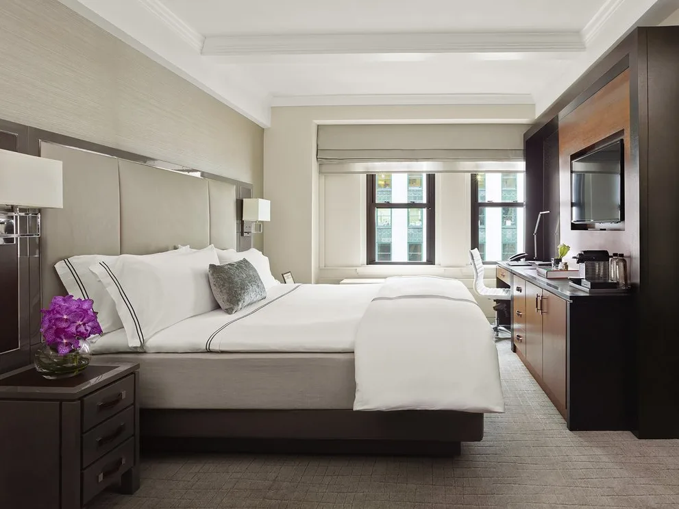Bedroom at The Quin, a Hilton Club, with a work desk and city-view windows